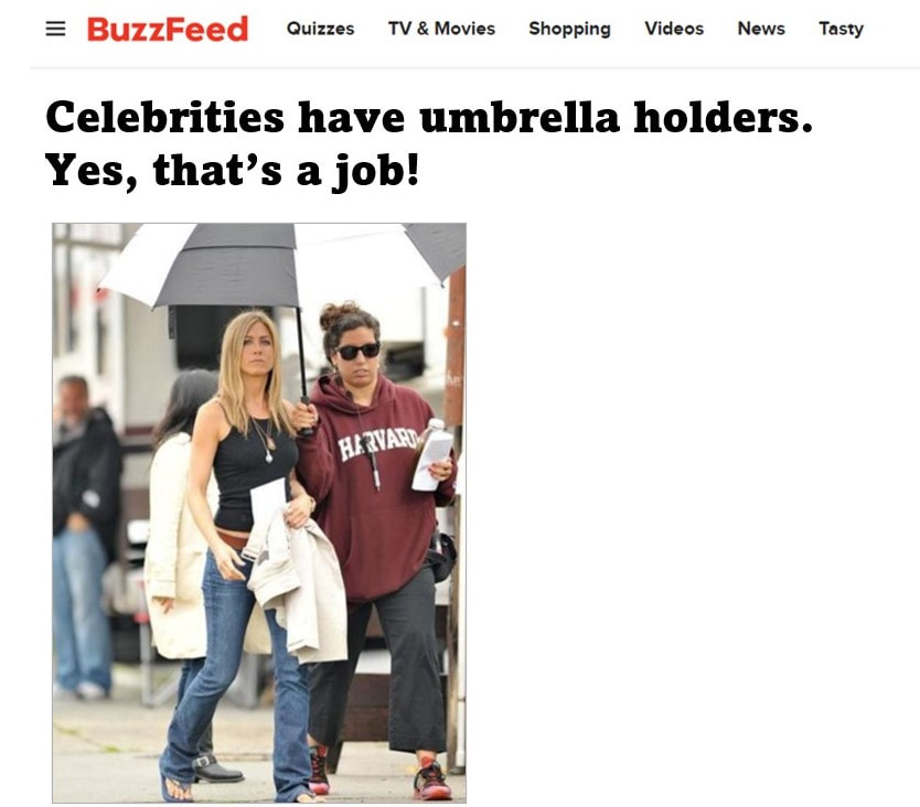 assistants hold umbrellas for celebrities